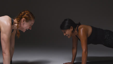 Studio-Shot-Of-Two-Mature-Women-Wearing-Gym-Fitness-Clothing-Doing-Plank-Exercise-Together-3